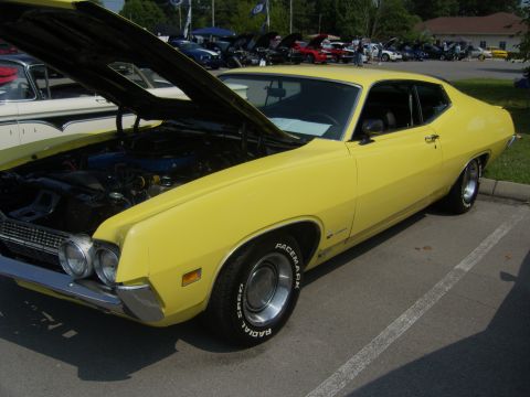 2007 Ford Mustang - A bright yellow 1970 Ford Torino GT coupe is displayed with its hood open at a car show.