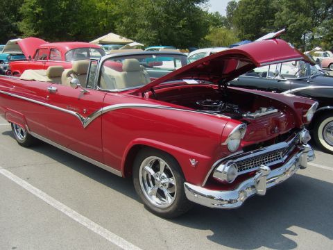 2007 Ford Mustang - A red convertible classic car is displayed with its hood open at a car show.