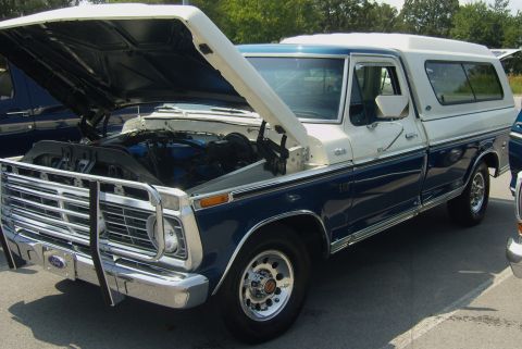 2007 Ford Mustang - This classic Ford pickup has a prominent chrome grille guard and a white camper shell over the bed.