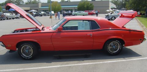 2007 Ford Mustang - A red classic coupe is displayed with its hood and trunk open at an outdoor event with other vehicles present.