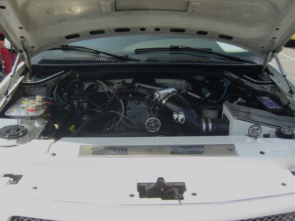 Engine bay with black intake Moon Eyes logo and JLP Racing plaque