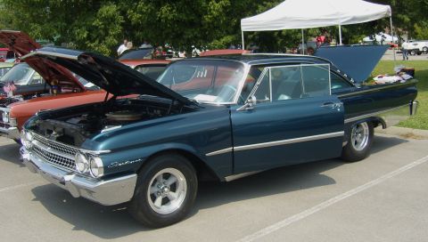 2007 Ford Mustang - A classic 1960 Ford Galaxie is displayed with its hood and driver's door open at a car show.