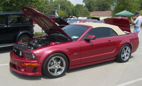 2007 Ford Mustang - Red 2007 Ford Mustang GT convertible at a car show, with hoods open.