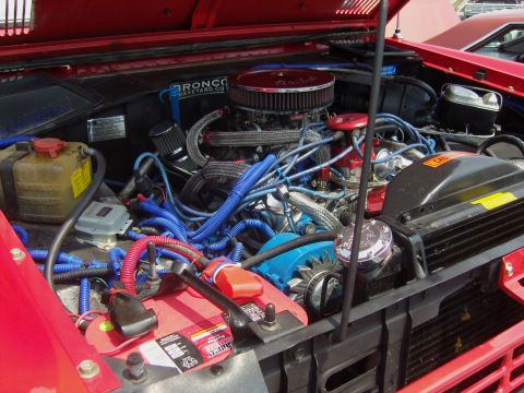 2007 Ford Mustang - Engine bay of a red vehicle, a V8 engine with extensive blue wiring and a chrome air cleaner assembly.