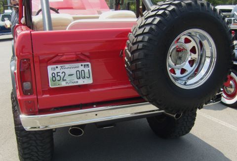 2007 Ford Mustang - The rear of a red SUV is shown, a large spare tire mounted on the back and a Tennessee license plate.