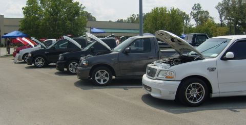 2007 Ford Mustang - Several Ford F-150 Lightning trucks are parked in a row with their hoods raised.