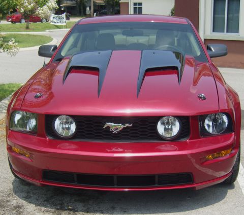 2007 Ford Mustang - The front of a red 2007 Ford Mustang is shown with a custom black hood scoop.