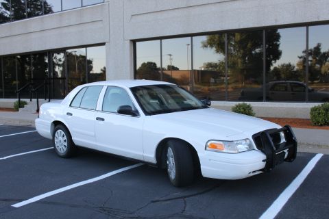 2003 Ford Crown Victoria - White 2003 Ford Crown Victoria with a black push bar parked in a lot.