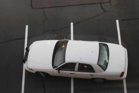 2003 Ford Crown Victoria - A white 2003 Ford Crown Victoria is parked in a lot, seen from a high angle.