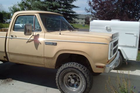 2006 Ford E350 - A tan Dodge pickup truck is parked next to a white trailer.