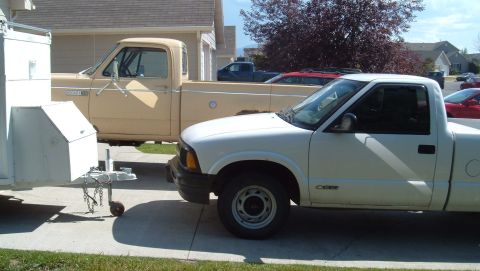 2006 Ford E350 - White Chevy S10 and tan Dodge pickup trucks are parked in a driveway with a trailer.