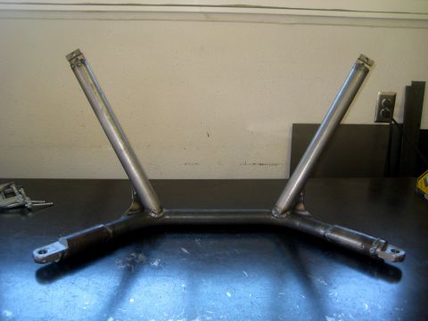 1996 Ford Bronco - A custom-fabricated metal part, possibly for a vehicle's suspension, is shown on a workbench.