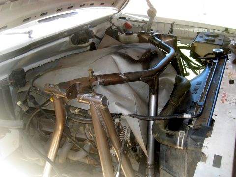 1996 Ford Bronco - Custom roll cage installed in the engine bay, obscuring some components.