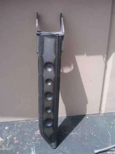 1986 Ford Bronco - Custom metal part with welds and circular indentations, likely for automotive use.