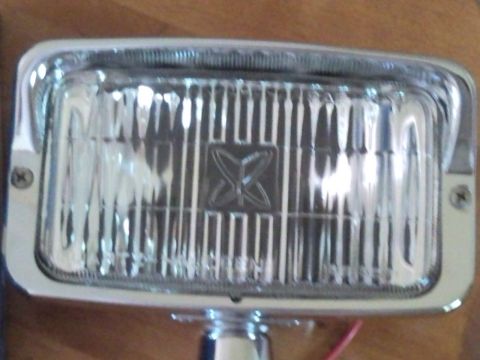 1988 Chevrolet Suburban - Close-up of a single automotive headlight assembly with a chrome bezel and ribbed lens.