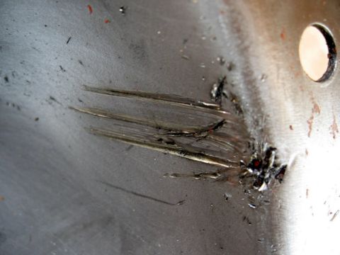 1995 Ford F-150 - A metal surface shows significant damage, including deep scratches and a hole.