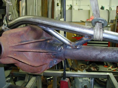 1979 Ford Bronco - Close-up of a rusty rear axle assembly with added metal tubing, being worked on in a garage setting with a "Supermotors.net" watermark.