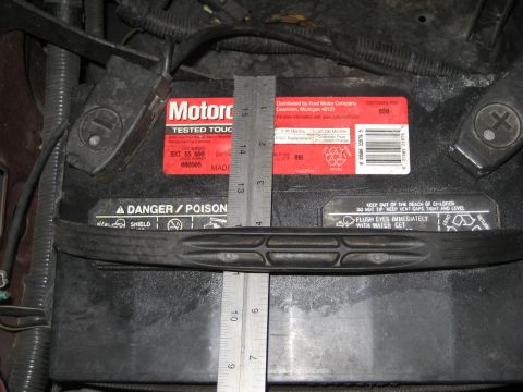 1996 Ford Bronco - Measuring a car battery, which is labeled as a Motorcraft product distributed by Ford.