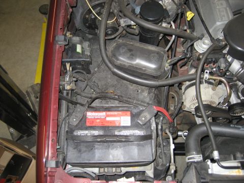 1996 Ford Bronco - Close-up view of the engine bay, focusing on the Motorcraft battery and surrounding components.