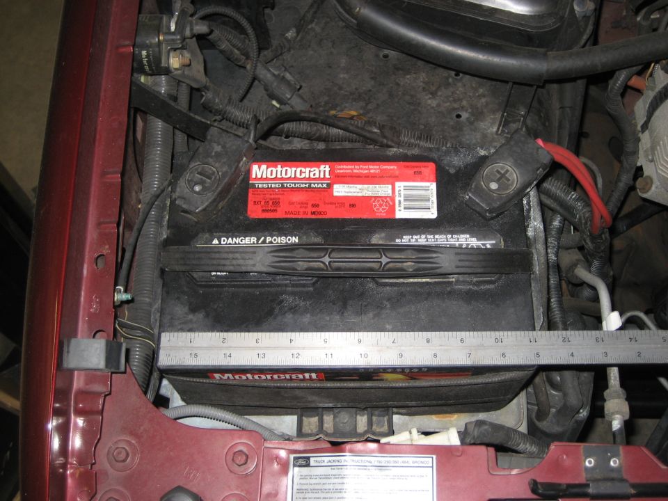 Motorcraft Tested Tough Max battery with a ruler across it, showing engine bay components