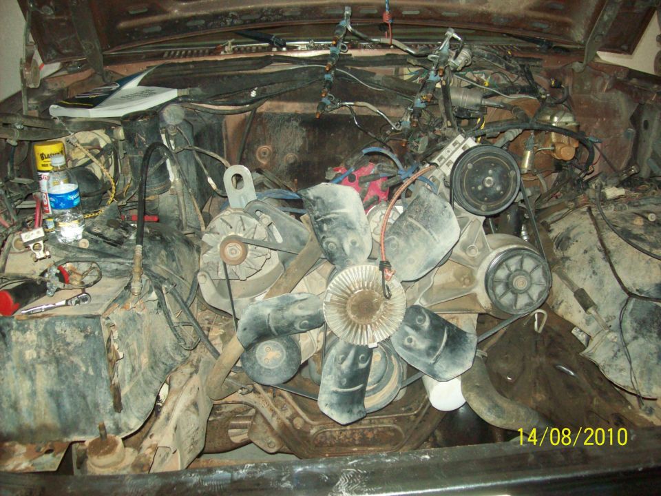 Engine bay with large fan, belts, and wiring