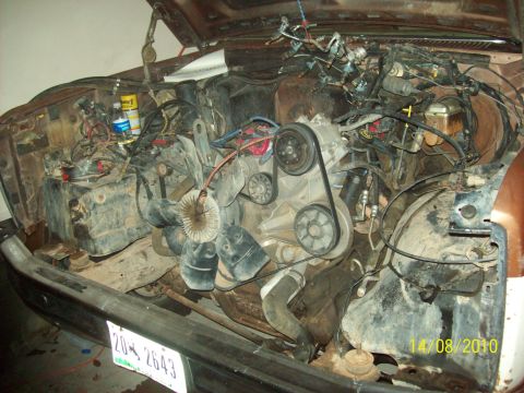 1985 Ford Bronco - Vehicle engine bay with engine removed, revealing internal components and wiring harnesses.