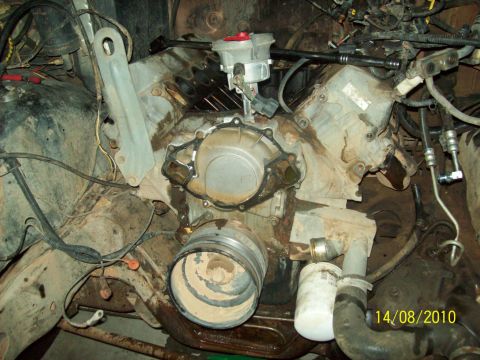 1985 Ford Bronco - Close-up view of a disassembled engine, focusing on the water pump and distributor assembly.