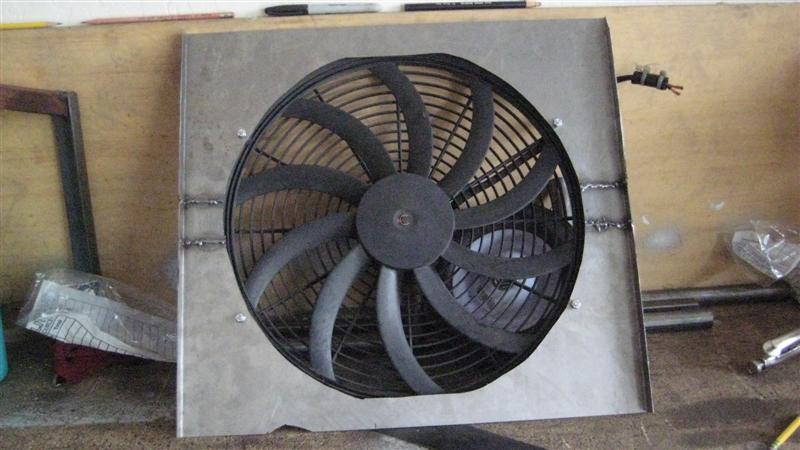 Black electric cooling fan mounted in a metal shroud