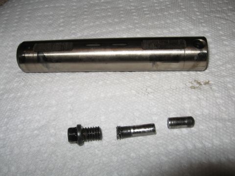 1995 Ford F-150 - Disassembled metal automotive part with associated hardware on a paper towel surface.