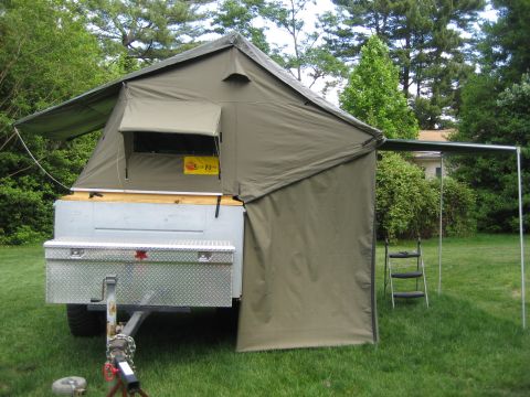 1996 Ford Bronco - Tent trailer with a toolbox and awning extended, parked outdoors on a lawn.