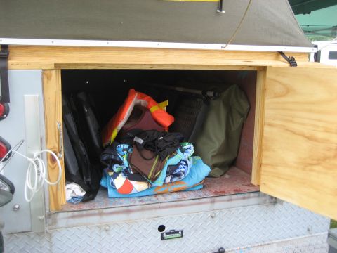1996 Ford Bronco - A storage compartment is open, revealing camping gear and personal items inside.
