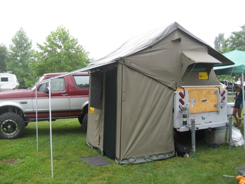 Red and silver 1996 Ford Bronco parked next to a pop-up camper trailer