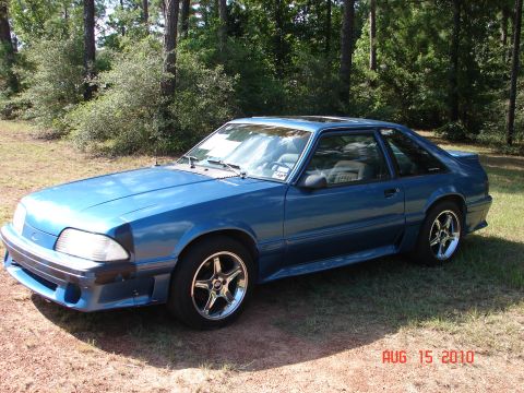 1987 Ford Bronco - This blue coupe features aftermarket wheels, a sunroof, and a rear spoiler, indicative of a late 1980s model.