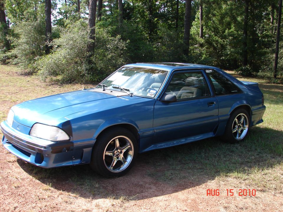 Blue coupe with aftermarket wheels, sunroof, and a rear spoiler