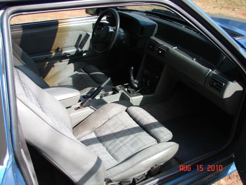 1987 Ford Bronco - The interior of a car shows gray plaid seats and dashboard details.