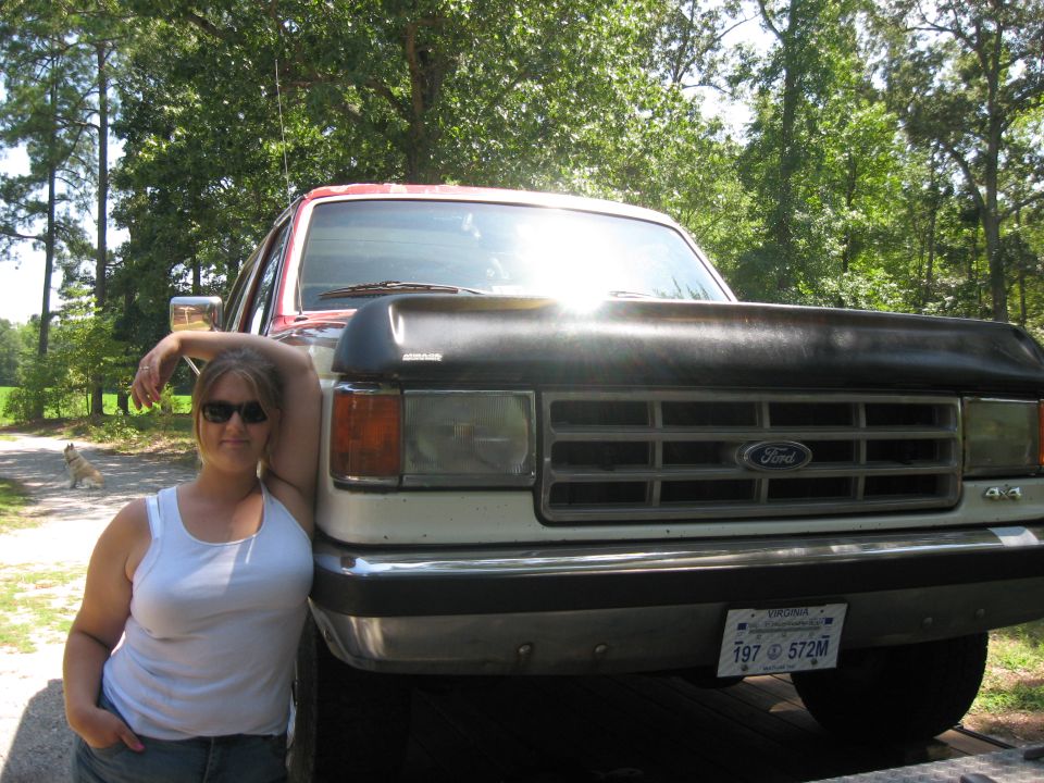 1987 Ford Bronco, white and red, front view, with a woman leaning on it