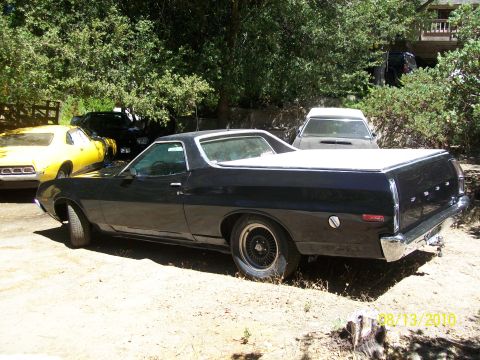 1972 Ford Ranchero - A black 1972 Ford Ranchero is parked outdoors next to other vehicles.