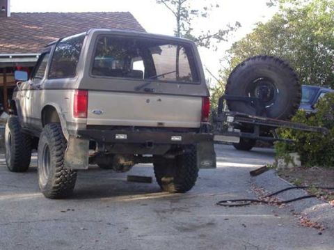 1990 Ford Bronco II - Swingout open, showing Hi-Lift jack (a shovel also goes above the jack). No gas cans yet... With the little V6 that gives low-20s MPG, havi…