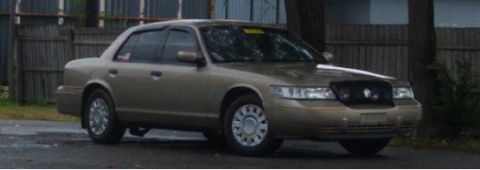 2000 Mercury Grand Marquis - Gold 2000 Mercury Grand Marquis sedan with a black grille.