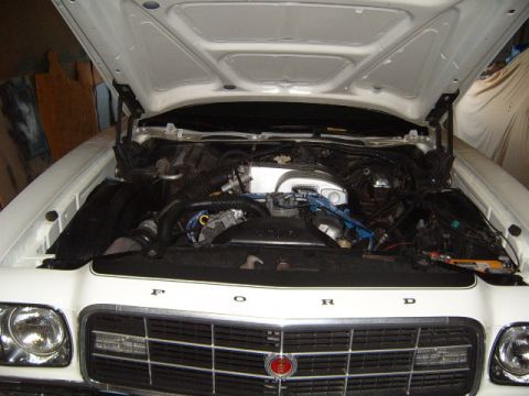 1973 Ford Ranchero - Engine bay of a 1973 Ford Ranchero, hood is open, showing the engine and front grille.