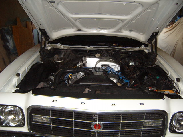 1973 Ford Ranchero engine bay with hood open, showing engine components and grille