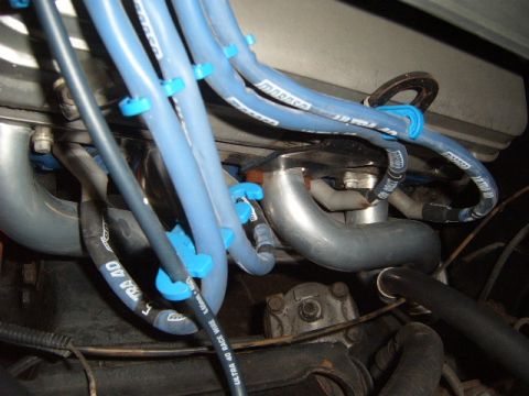 1973 Ford Ranchero - A view of the engine bay focuses on the spark plug wires and exhaust system components.