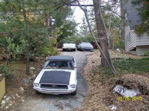 1968 Ford Mustang - 1968 Ford Mustang convertible with black hood and top, parked on a driveway with other vehicles.