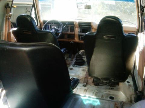 1986 Ford Bronco - Interior of a 1986 Ford Bronco, showing racing seats and a manual shifter, with the dashboard visible.