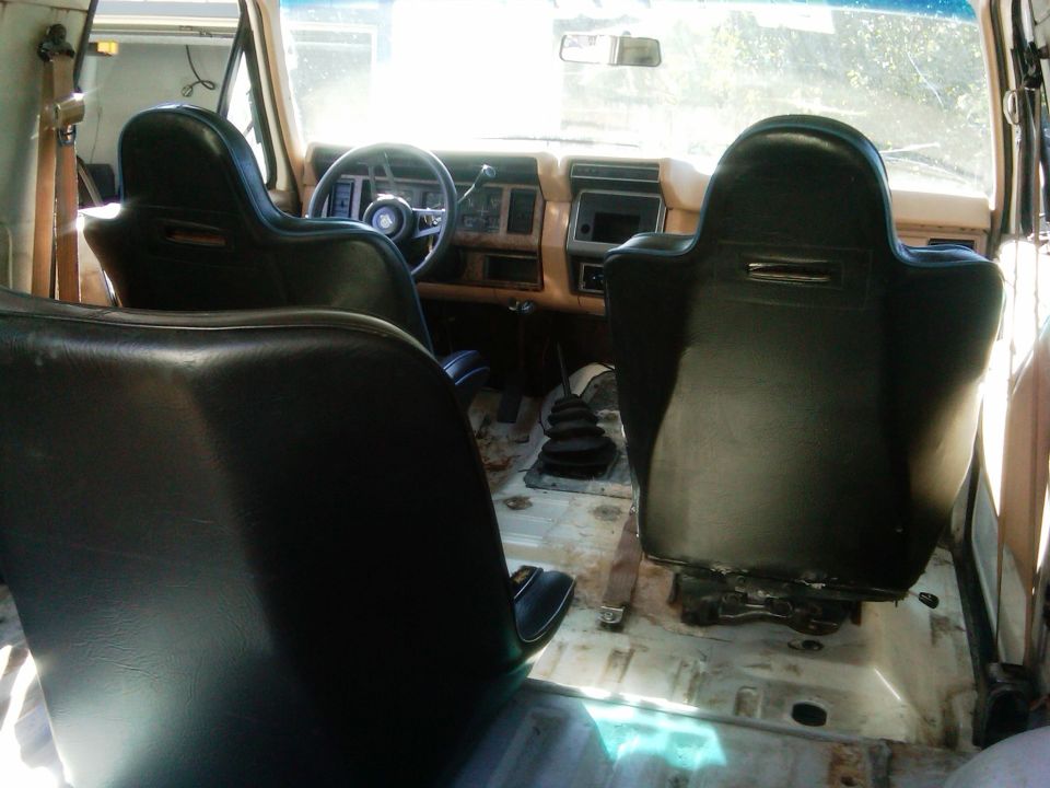 Interior view of a 1986 Ford Bronco with racing seats and a manual transmission
