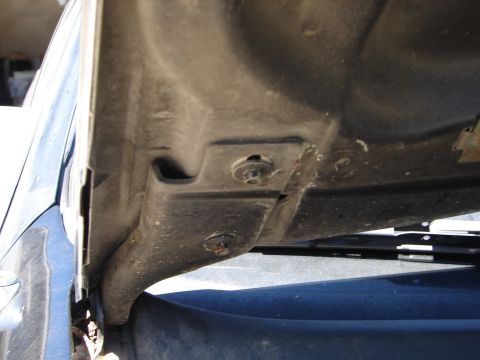 1992 Ford Taurus - Close-up view of the underside of a vehicle's hood, showing mounting hardware and structural components.