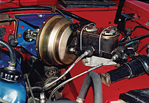 1986 Ford Bronco - Close-up of a brake booster and master cylinder assembly, likely from a vehicle's engine bay.