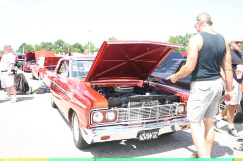 1968 Shelby GT500 - A red 1964 Ford Falcon is displayed with its hood up at an outdoor car show.