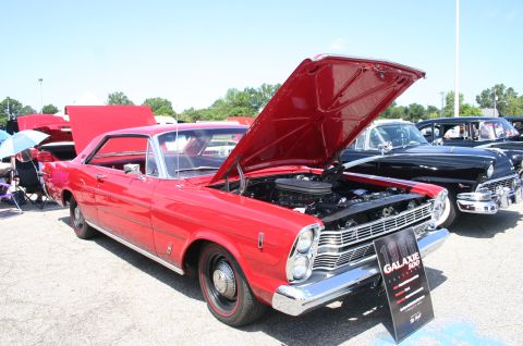 1968 Shelby GT500 - A red 1966 Ford Galaxie 500 is displayed with its hood open at an outdoor car show.