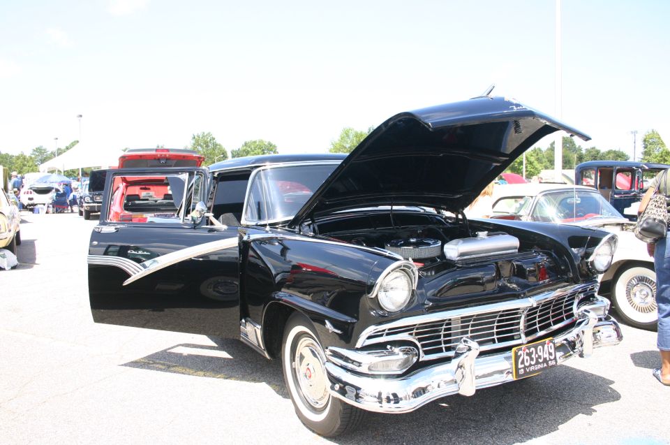 Black 1955 sedan, hood and door open, showing engine and interior
